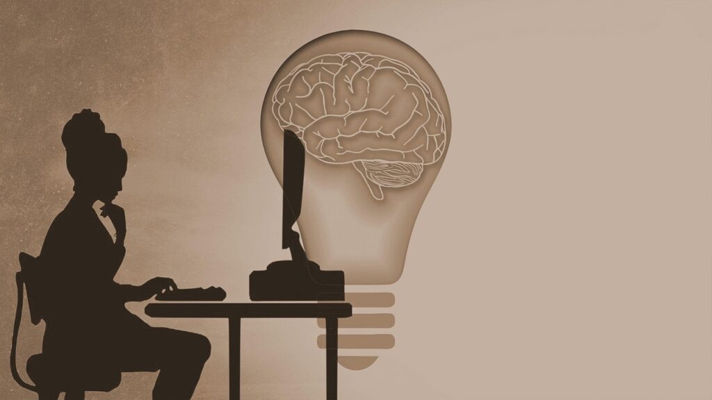 Silhouette réfléchissant devant un ordinateur.