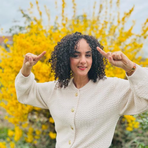 Femme devant un buisson jaune.